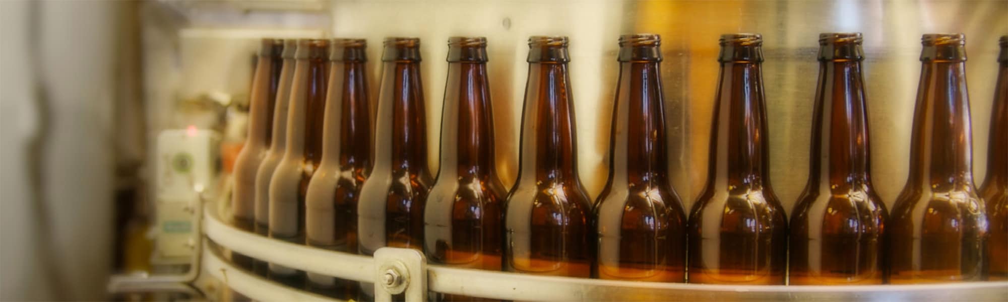 Brown bottles on a conveyor in a beverage processing plant
