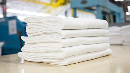 Stack of white towels in a commercial laundry facility