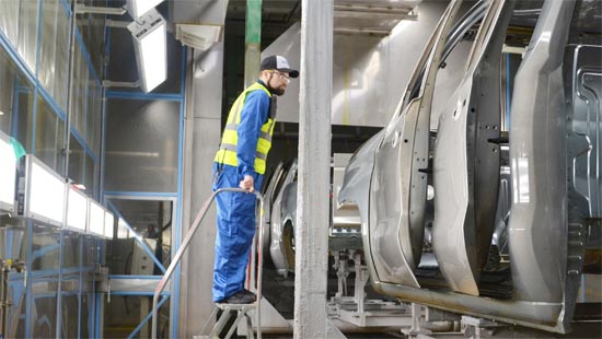 automotive paint expert inspecting vehicle bodies exiting pretreatment