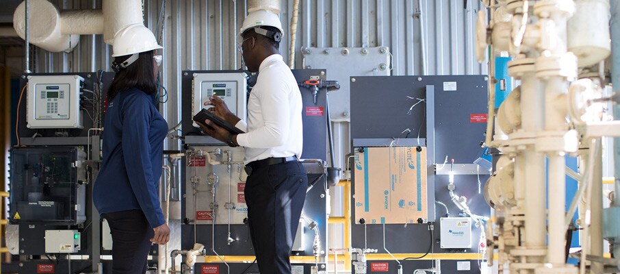 Two Ecolab associates in a facility using Ecolab 3D TRASAR Technology.