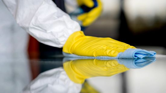 Gloved hand cleaning a data center with an Ecolab towel.