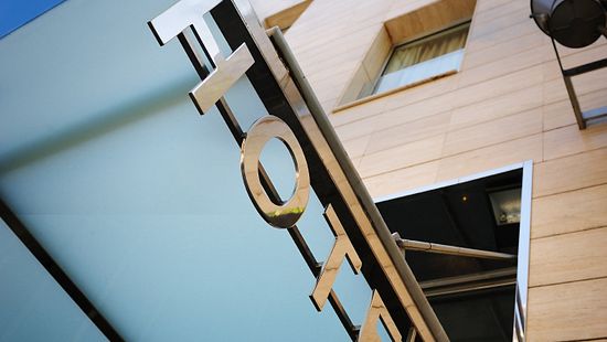 Upward angle of a hotel sign of a six-story hotel.